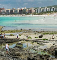 Part of Praia do Forte, with lots of rocks, people walking, located in the city of Cabo Frio, Rio de Janeiro.