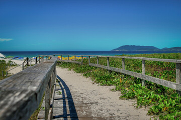 Path leading to the edge of a beautiful beach with mountains in the background, located in the city of Cabo Frio, Rio de Janeiro.