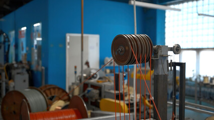 Rotating industrial machine with coils and wires. Creative. Workshop at the industrial plant with spinning machines.