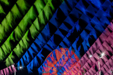 roda gigante iluminada em movimento e bandeiras coloridas de festa junina