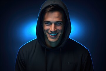 Portrait of happy young man in black hoodie in neon light.