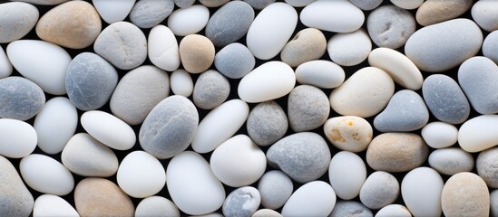 An up-close view of a collection of white round stones, showcasing their unique textures and shapes. The rocks are tightly grouped together, creating an interesting visual pattern.