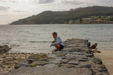 Fototapeta na wymiar young boy in a beach with rocks