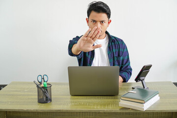 young asian freelancer in workplace making stop sign with hands isolated on white background