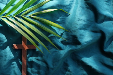 Palm leaves with wooden crucifix cross flat lay composition. Palm sunday celebration background.