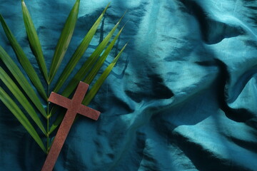 Palm leaves with wooden crucifix cross flat lay composition. Palm sunday celebration background.