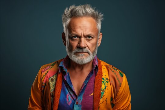 Portrait of an old man with a gray beard and mustache in a colorful shirt.