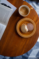 丸テーブル上の本とコーヒーとバターサンド