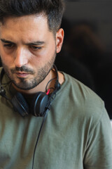 Portrait of a concentrated DJ in his studio with headphones removed