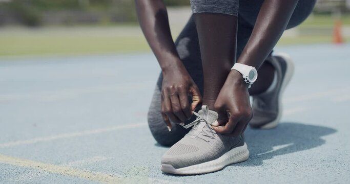 Person, runner and tie shoelace in stadium or starting line for exercise safety, speed or competition. Athlete, feet and hands on field as sprinter or sport training health, marathon or challenge