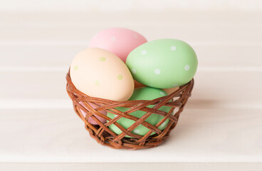 Colorful easter eggs in bowl on wooden table