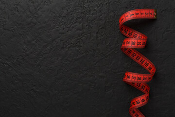 Measuring tape on concrete background, top, view