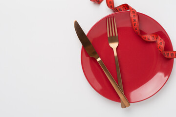 Measuring tape with empty plate on color background, top, view. Weight loss concept