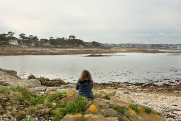 Personne qui regarde la mer en Bretagne
