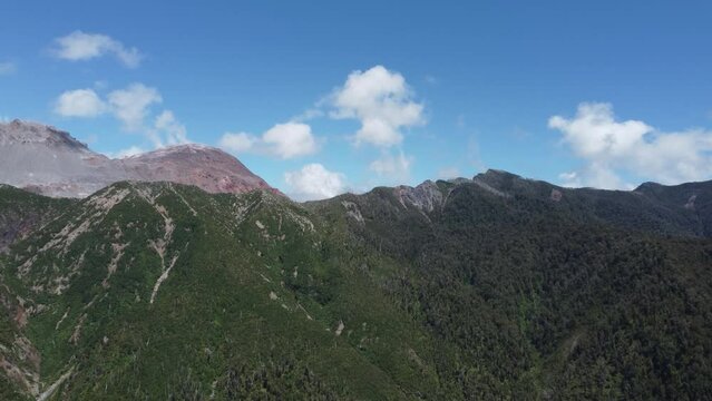 Camera panning across Volcano Chaiten with smoke plumes escaping the cone of the Volcano
