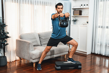Fototapeta na wymiar Athletic body and active sporty man doing squat with kettlebell weight for effective targeting muscle gain at gaiety home as concept of healthy fit body home workout lifestyle.