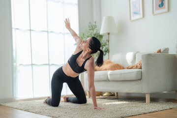 close up women confident training yoga. Athletic women in sportswear doing fitness stretching exercises at home in the living room. Sport and recreation concept. Yoga teacher is helping girl.