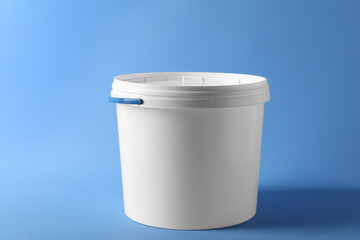 One plastic bucket with lid on light blue background