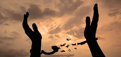 Freedom. Woman with broken handcuffs against cloudy sky at sunset, closeup. Banner design