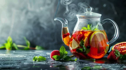 Foto op Plexiglas Homemade healthy hot fruit tea with fresh ripe orange, apple, mint leaves and twigs of thyme in glass teapot or kettle on grey kitchen background. © Nataliya