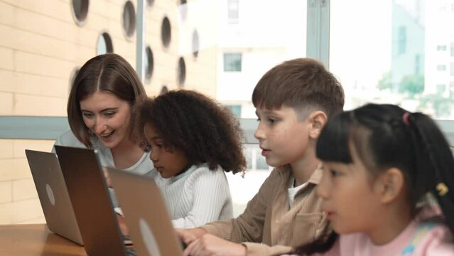 Smart teacher teaching and looking student using laptop at classroom. Professional instructor explained about programing engineering code or prompt while studying and learning program. Erudition.