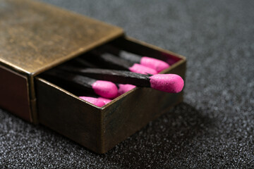 angle view copper matchbox with pink color match sticks at horizontal composition
