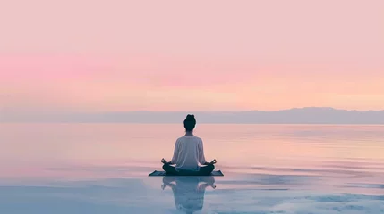 Fototapeten Woman meditating at peaceful lake seaside calming concept © The Stock Image Bank