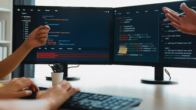 Slow motion back end software developer engineer for computer programming working together on debugging writing computing code, solving complex algorithms display on monitor in office. Burgeoning