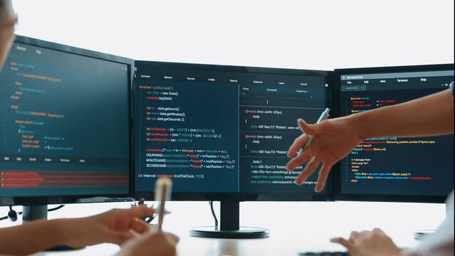Slow motion back end software developer engineer for computer programming working together on debugging writing computing code, solving complex algorithms display on monitor in office. Burgeoning
