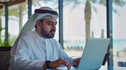 Arab saudi man working online with a laptop and smartwatch in a coffee shop or an hotel bar with a window and outdoor terrace in the background : Generative AI - Powered by Adobe