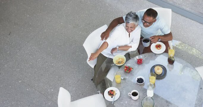 Biracial couple enjoys a healthy breakfast together, with a top-down view with copy space