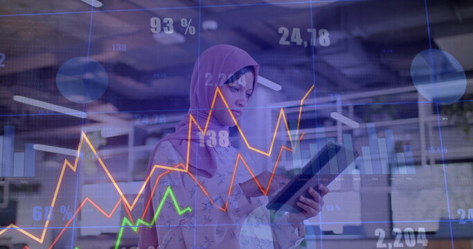 Image of financial data processing over biracial businesswoman in hijab working in office