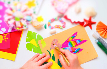 Child making homemade greeting card, applique with bird,  hummingbird or colibri and flowers from...