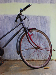 Close-up view of an old bicycle next to a wall.