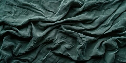 Abstract  dark green and wrinkled fabric weave of cotton or linen satin fabric lies texture background.
