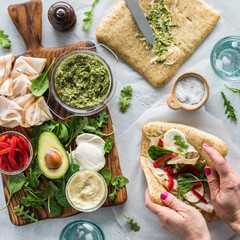 Preparing fresh pesto and deli turkey wraps. 