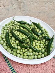 Grains or seed of Pisum sativum with Lycopersicon esculentum or Capsicum annuum L Green chilli or pea grains or seeds with Green chilli or garden pea seeds or grains with Green chilli