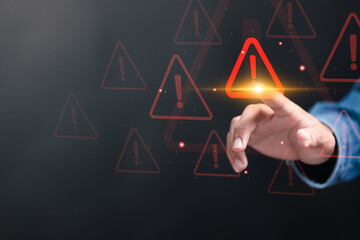 Business investment risks concept. Hand touching to warning sign on virtual screen for caution in...
