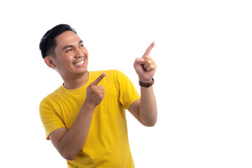 Portrait of excited handsome Asian man pointing finger at copy space for text advertisement isolated on white background