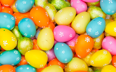 Fototapeta na wymiar Colorful Easter eggs on a white background with candy, sweets, and spring colors