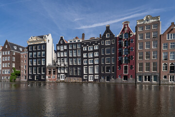 Typical Dutch canal houses along the Damrak in Amsterdam, The Netherlands.