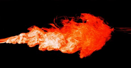 Fire artist performing extreme fire breathing, black background 
