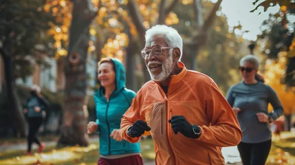 Keuken spatwand met foto A senior man with a beaming smile jogging in a park during autumn, surrounded by golden foliage. © Taskmanager