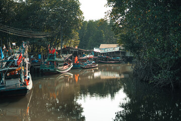 Fototapeta premium Fisherman's village and fishing boats at the canal by the sea.​Fisherman's village and fishing boats at the canal by the sea.​Fisherman's village and fishing boats at the canal by the sea.​