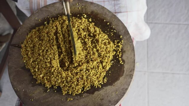 a Person is do chopping Balinese Herb Seasoning with Blakas, a Traditional Balinese Knife on the Wooden Board