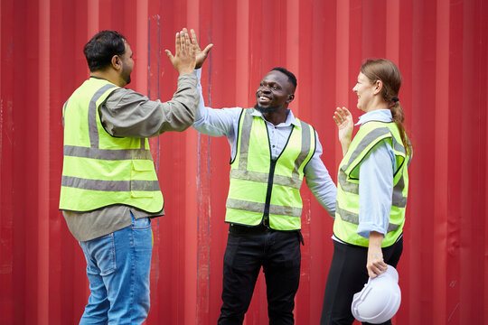 group of workers or engineer feeling happy and giving high five from success work in containers warehouse storage