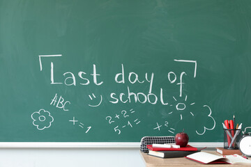 Text LAST DAY OF SCHOOL with drawings on blackboard in classroom