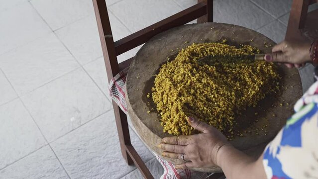 a Person is do chopping Balinese Herb Seasoning with Blakas, a Traditional Balinese Knife on the Wooden Board