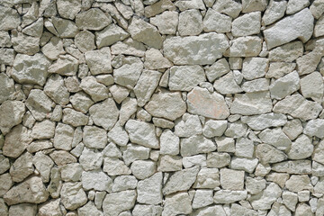 Fototapeta premium Decorative uneven cracked pattern of real stone wall surface with light pastel color and modern style. Interior and architecture concept