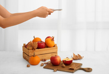 Female photographer taking photo of autumn composition in studio